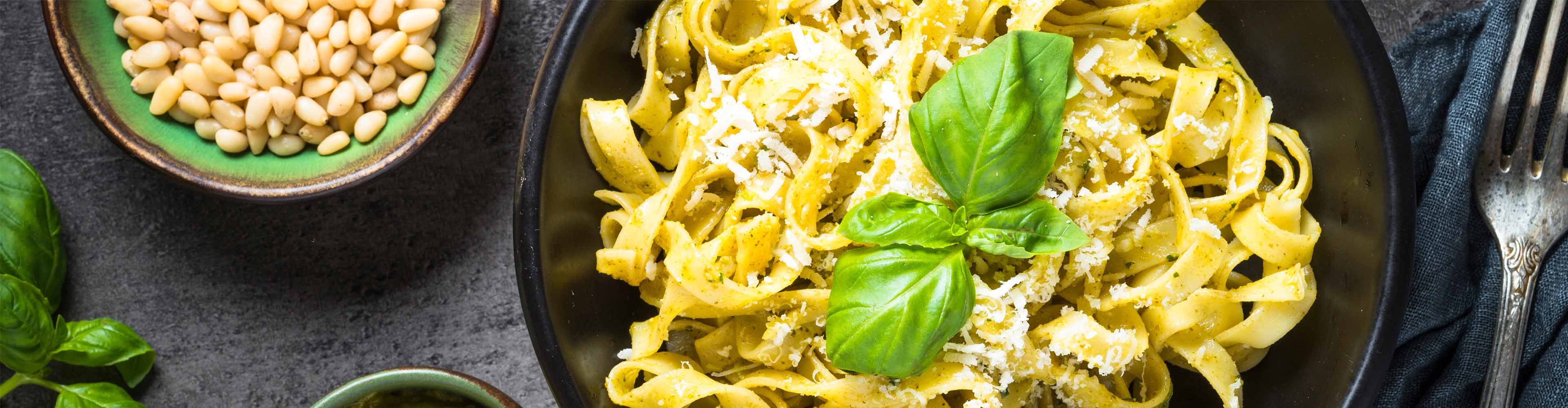 Pesto-Nudeln mit Basilikum, Parmesan und Pinienkernen.