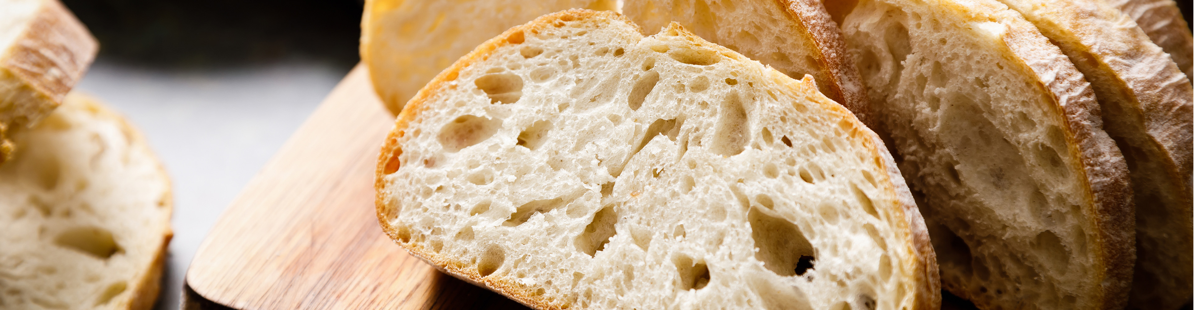 Nahaufnahme von Ciabatta-Brotstücken auf einem Holzbrett.