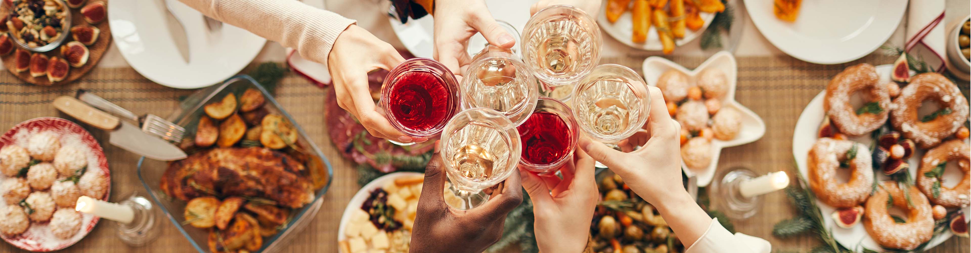 Festlicher Tisch mit Braten, Gebäck und Gläsern mit Rot- und Weißwein.