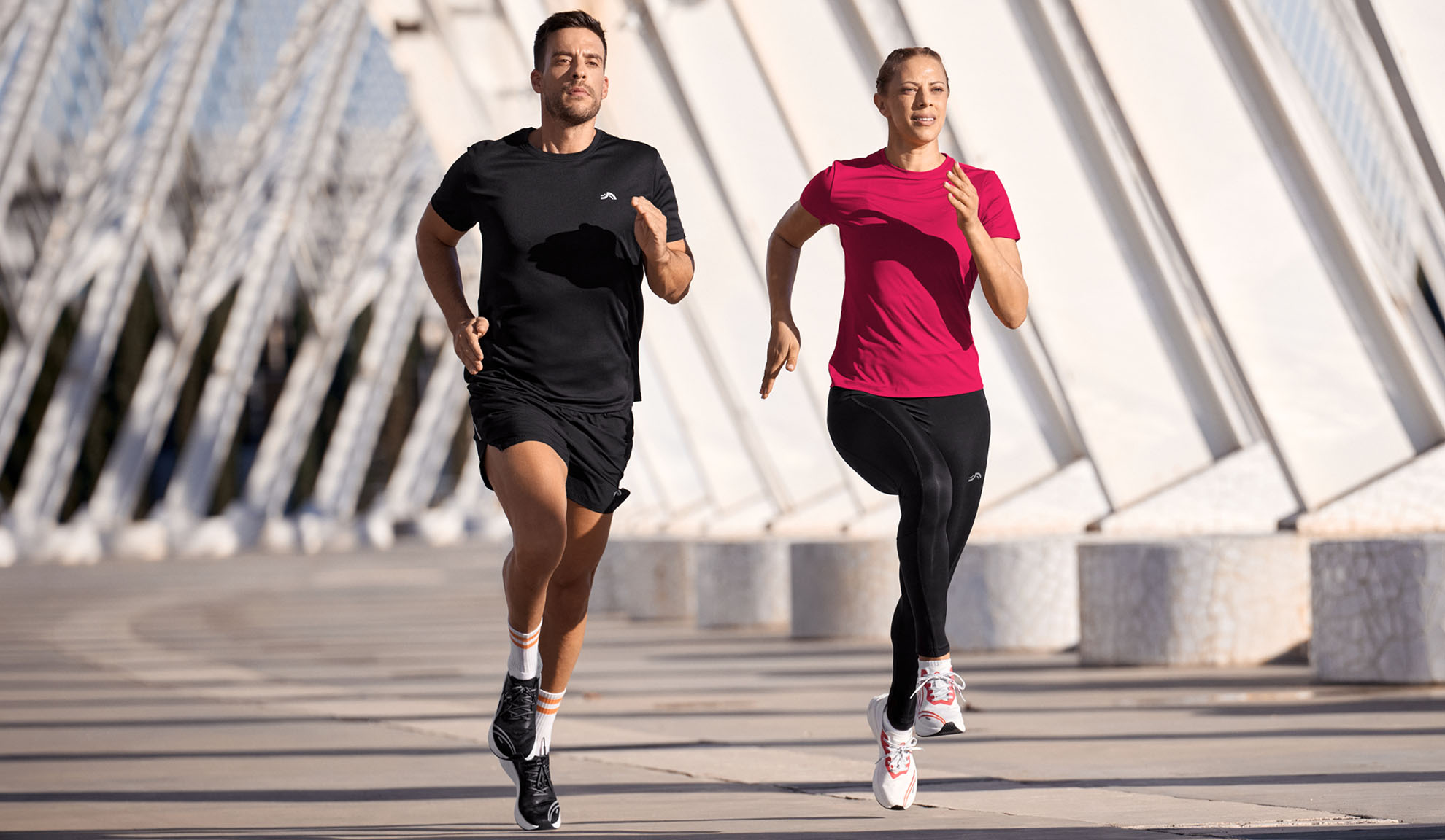 Mann und Frau laufen in Sportkleidung, T-Shirts und Leggings.