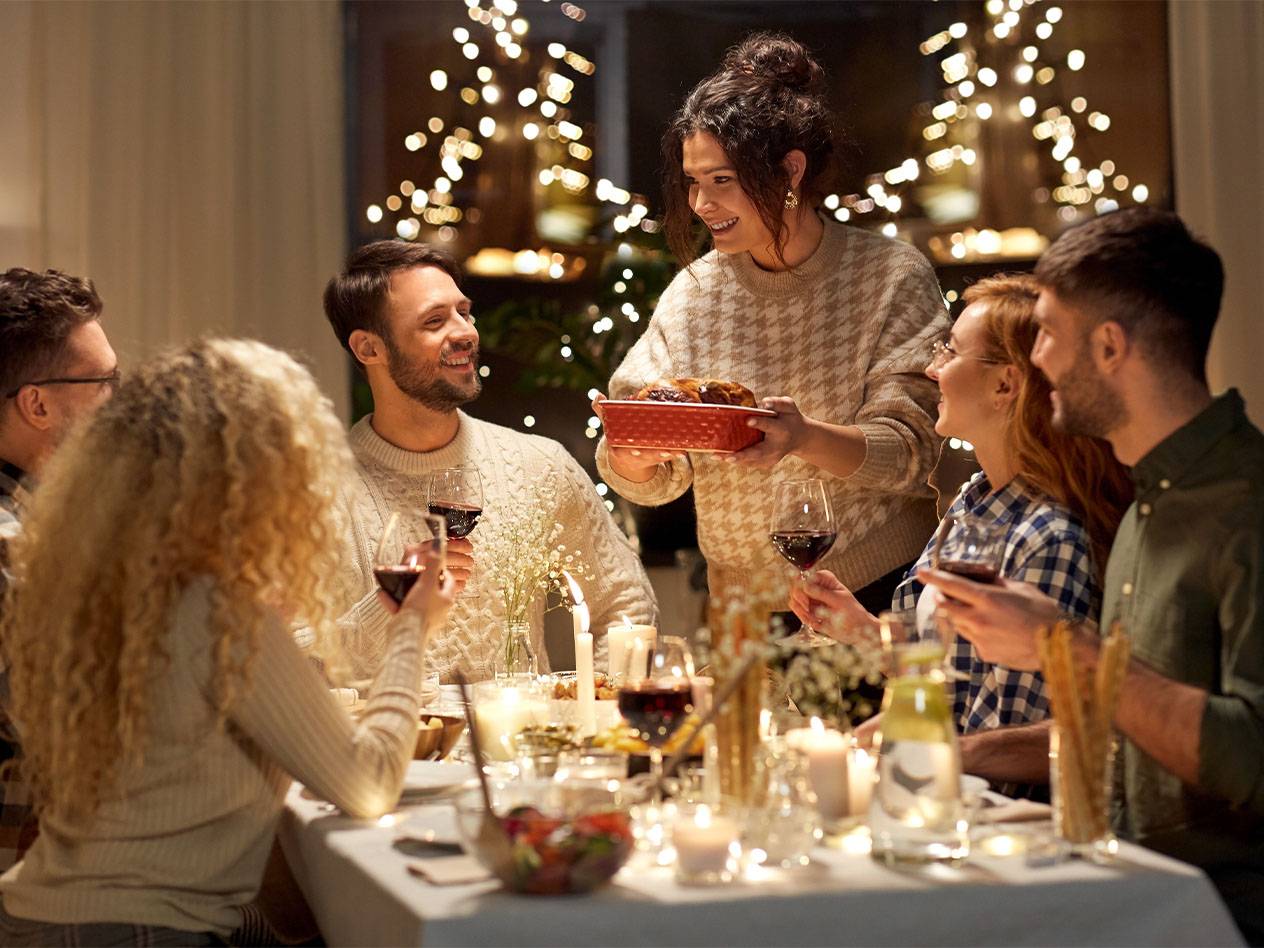 Freunde genießen ein festliches Abendessen mit Wein und Kerzenlicht.