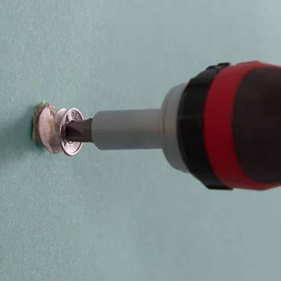 Elektrischer Schraubendreher mit Bohrer, der eine Schraube in die Wand dreht.